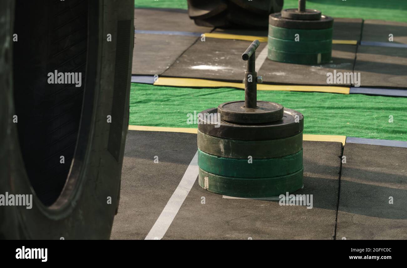 Barbells weights on vertical bar with handles on stadium rubber floor on iron man competition Stock Photo
