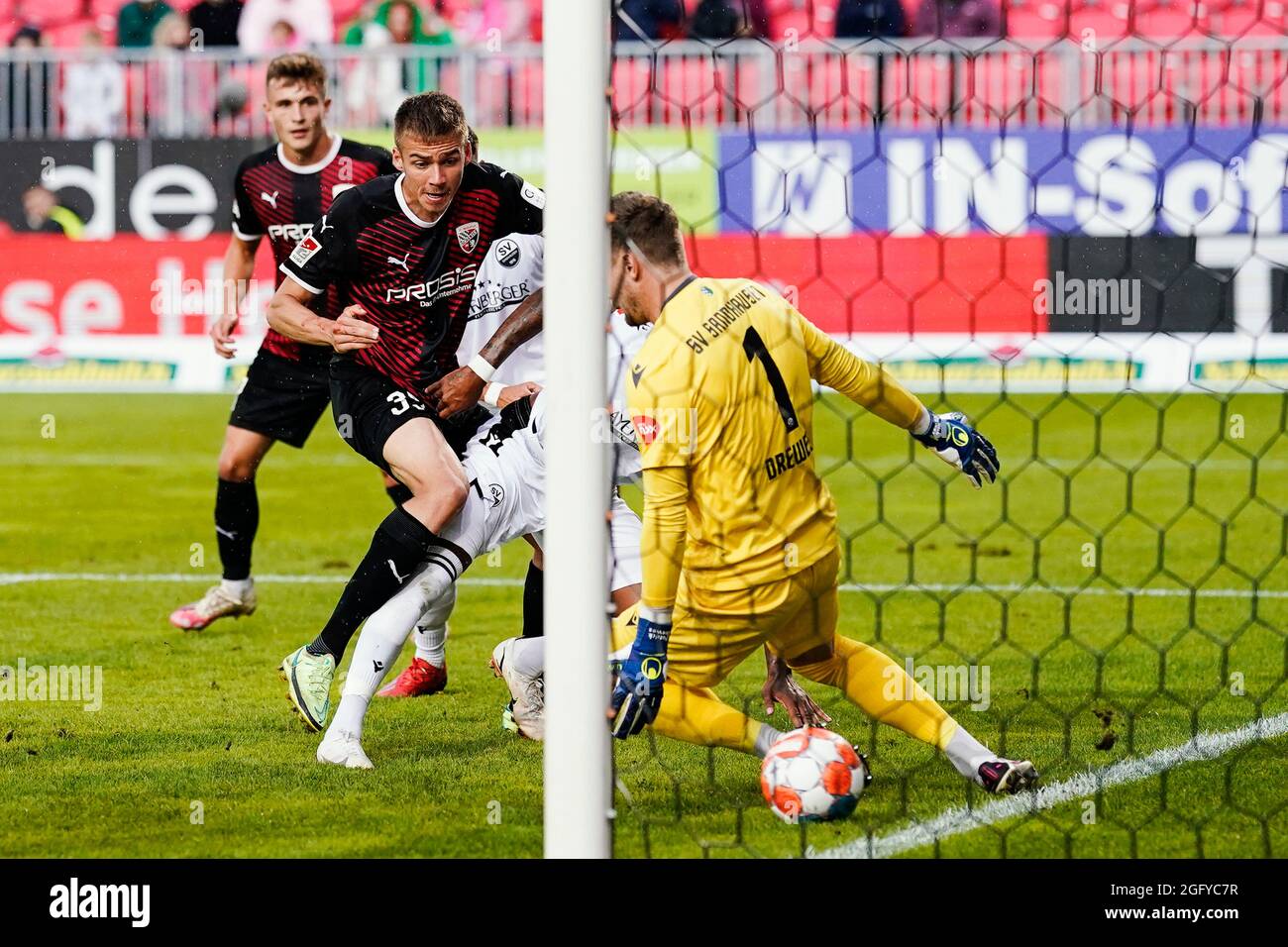 Sandhausen, Germany. 27th Aug, 2021. Football: 2nd Bundesliga, SV Sandhausen - FC Ingolstadt 04, Matchday 5, Hardtwaldstadion. Ingolstadt's Filip Bilbija (2nd from left) shoots past Sandhausen's goalkeeper Patrick Drewes to make it 0:1. Credit: Uwe Anspach/dpa - IMPORTANT NOTE: In accordance with the regulations of the DFL Deutsche Fußball Liga and/or the DFB Deutscher Fußball-Bund, it is prohibited to use or have used photographs taken in the stadium and/or of the match in the form of sequence pictures and/or video-like photo series./dpa/Alamy Live News Stock Photo