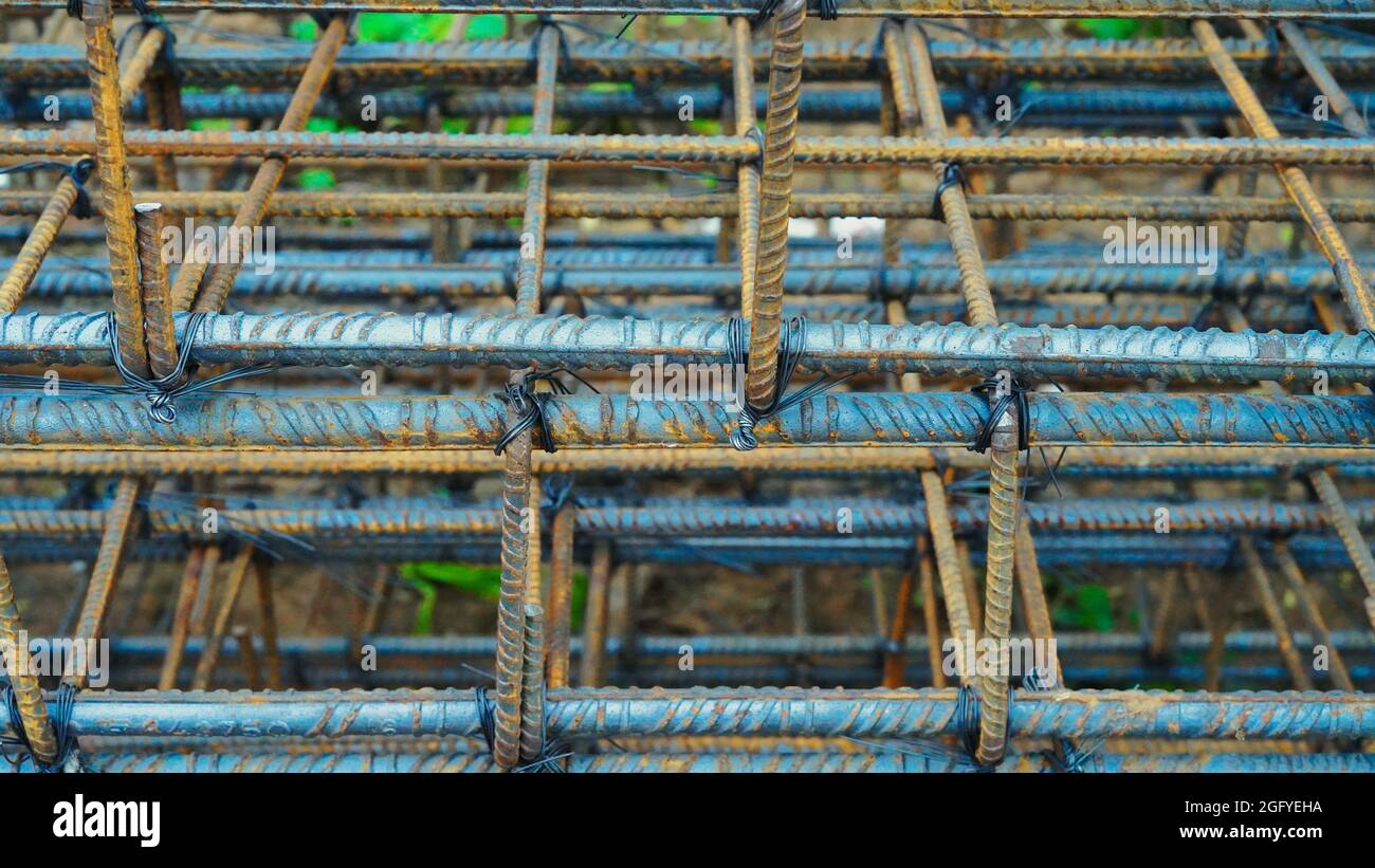 Rusty metal wiring is laid on the ground of house under construction. Preparation for making foundation of a building. Stock Photo