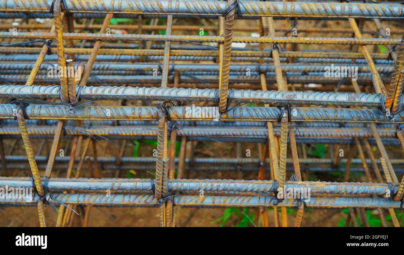Modern house under construction waits for concrete slab pouring.Rusty metal wiring is laid on the ground of house under construction. Stock Photo