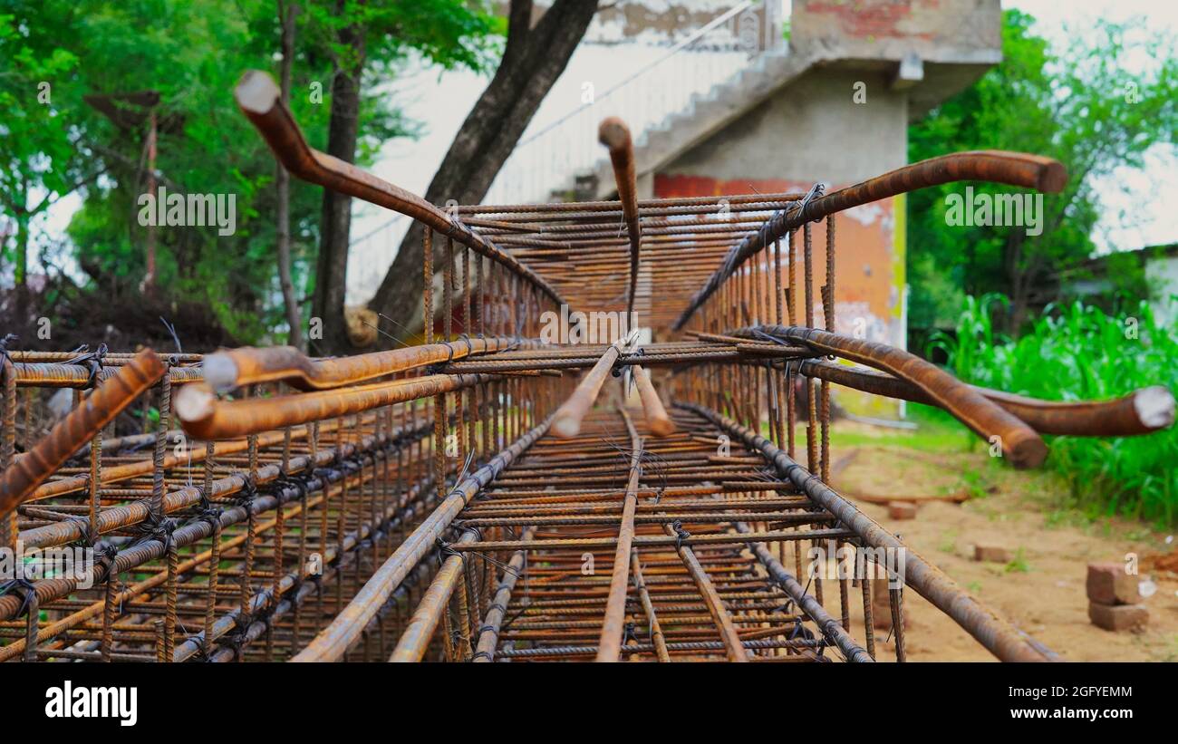 Rusty metal wiring is laid on the ground of house under construction. Preparation for making foundation of a building. Stock Photo