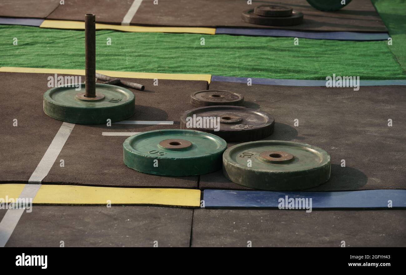 barbell weight disks on stadium rubber floor Stock Photo