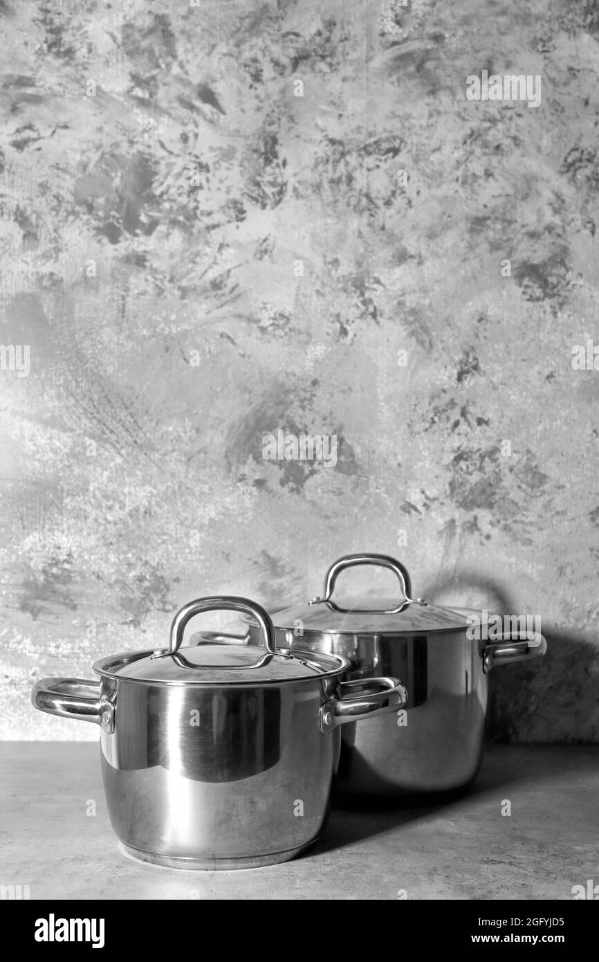 Metal pans with lids on textured wall background Stock Photo Alamy