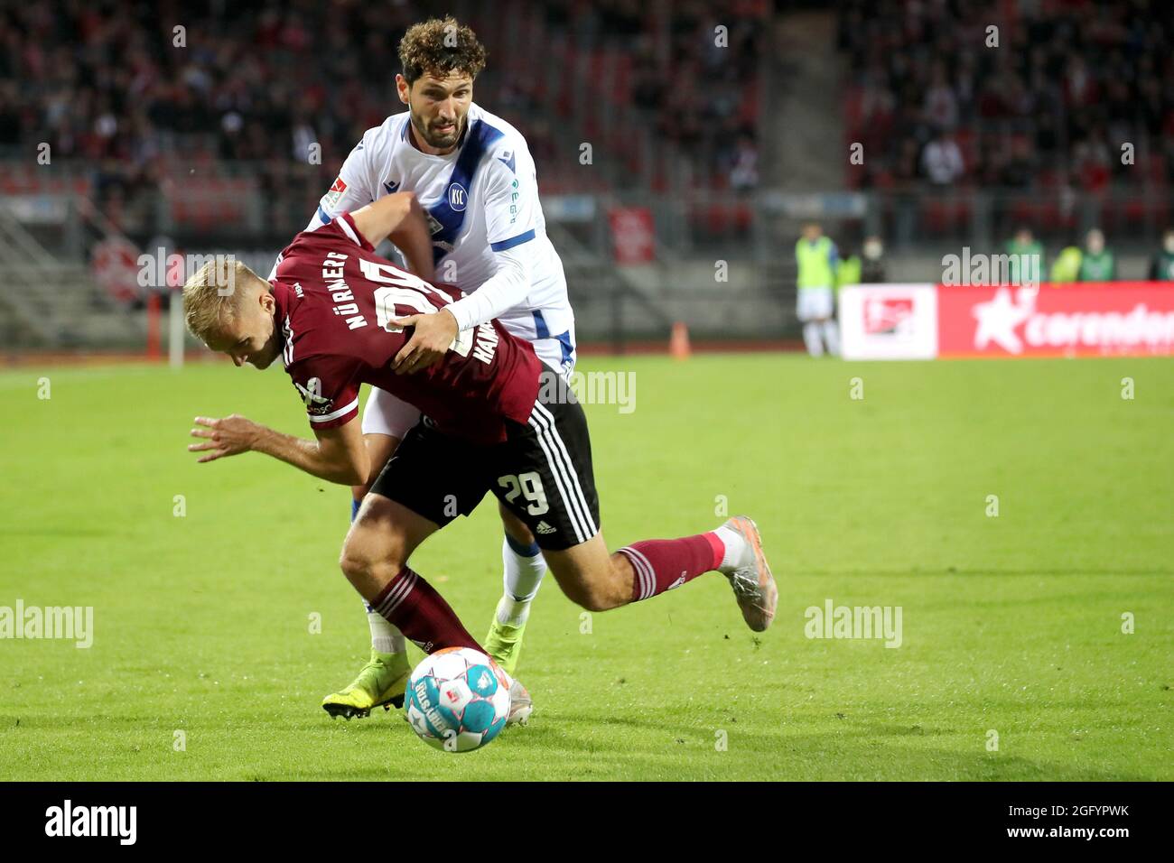 Nuremberg, Germany. 27th Aug, 2021. Football: 2nd Bundesliga, 1. FC Nürnberg - Karlsruher SC, Matchday 5 at Max Morlock Stadium. Nuremberg's Tim Handwerker (v) fights for the ball with Karlsruhe's Fabio Kaufmann. Credit: Daniel Karmann/dpa - IMPORTANT NOTE: In accordance with the regulations of the DFL Deutsche Fußball Liga and/or the DFB Deutscher Fußball-Bund, it is prohibited to use or have used photographs taken in the stadium and/or of the match in the form of sequence pictures and/or video-like photo series./dpa/Alamy Live News Stock Photo