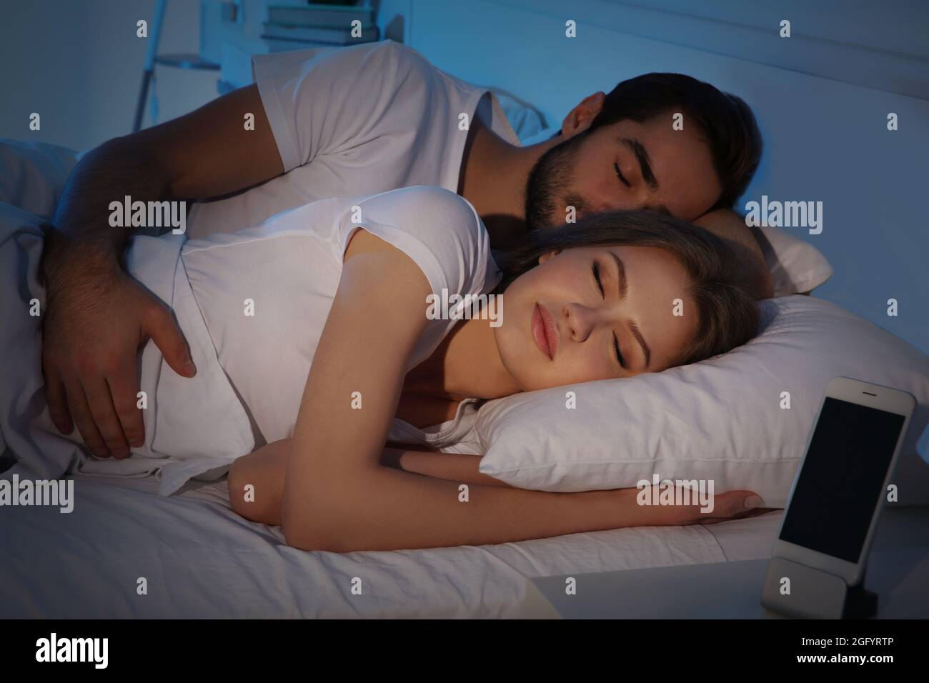 Young cute couple sleeping together in bed Stock Photo - Alamy