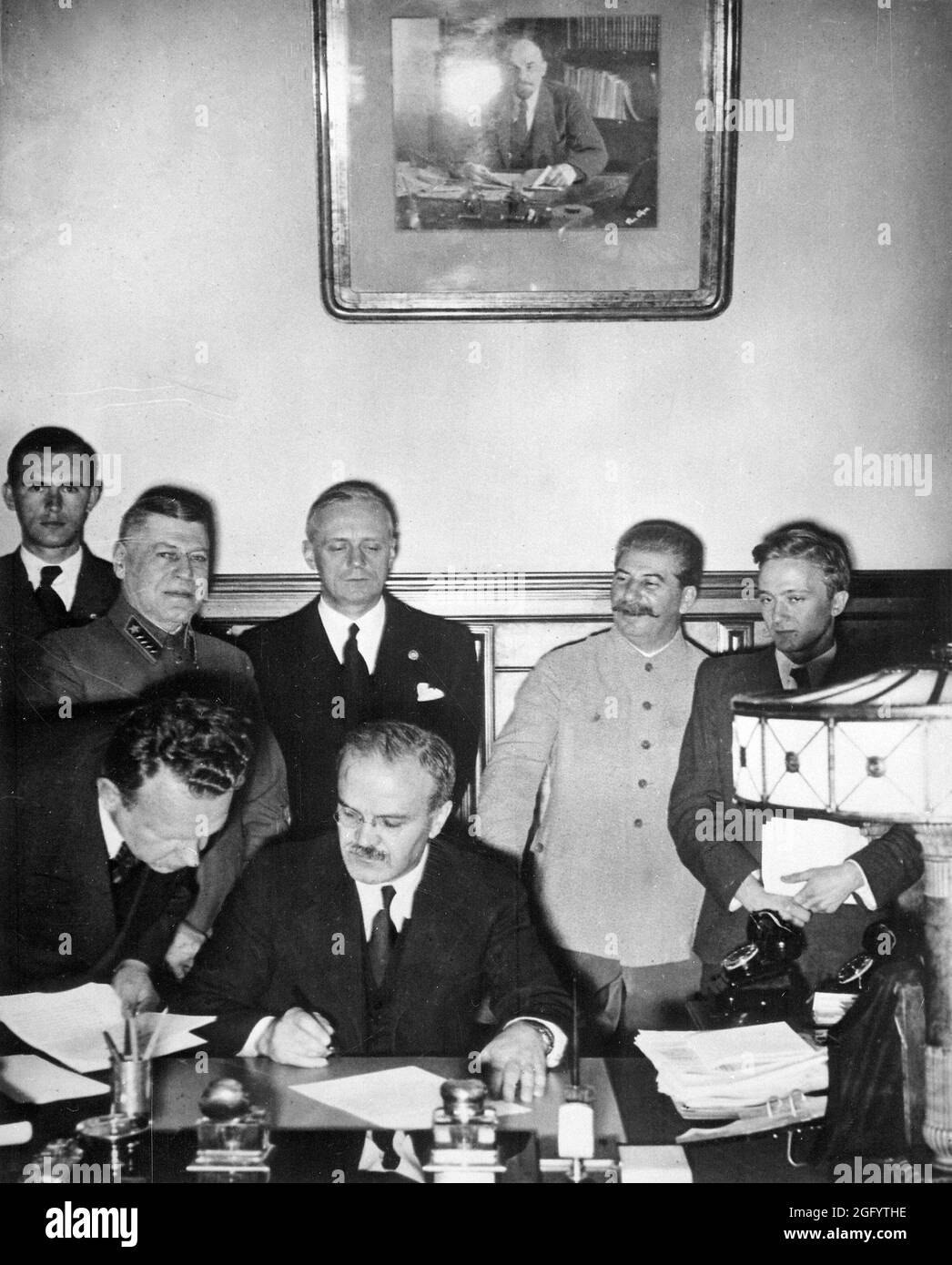 Soviet Foreign Minister Molotov signing the German-Soviet non-aggression pact (the Nazi-Soviet Pact or the Molotov-Ribbentrop Pact) with Joachim von Ribbentrop and Josef Stalin standing looking on. Stock Photo