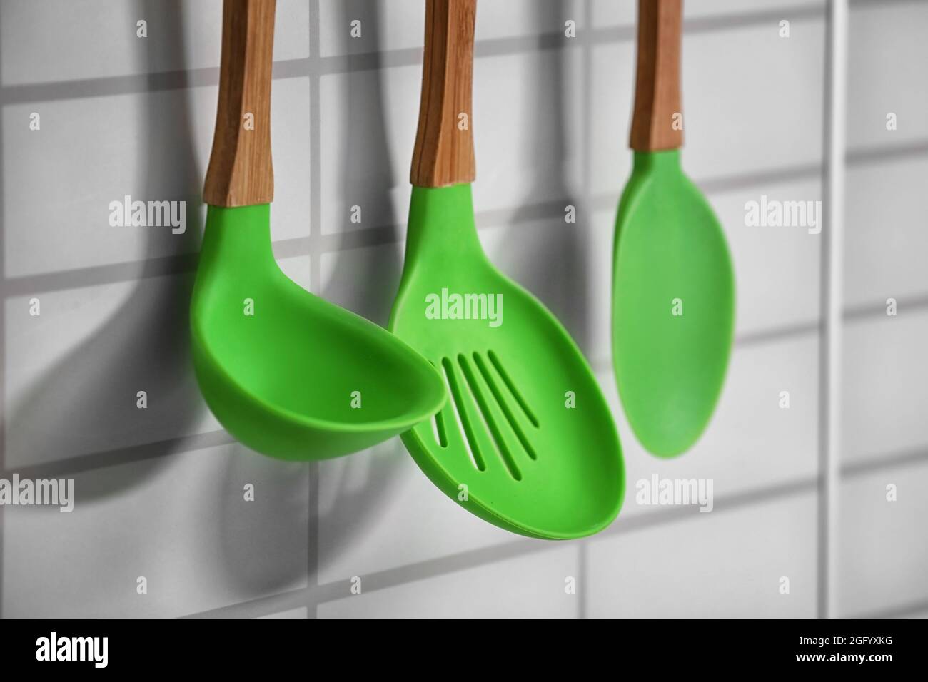 Set of wooden kitchen utensils hanging on wall Stock Photo Alamy