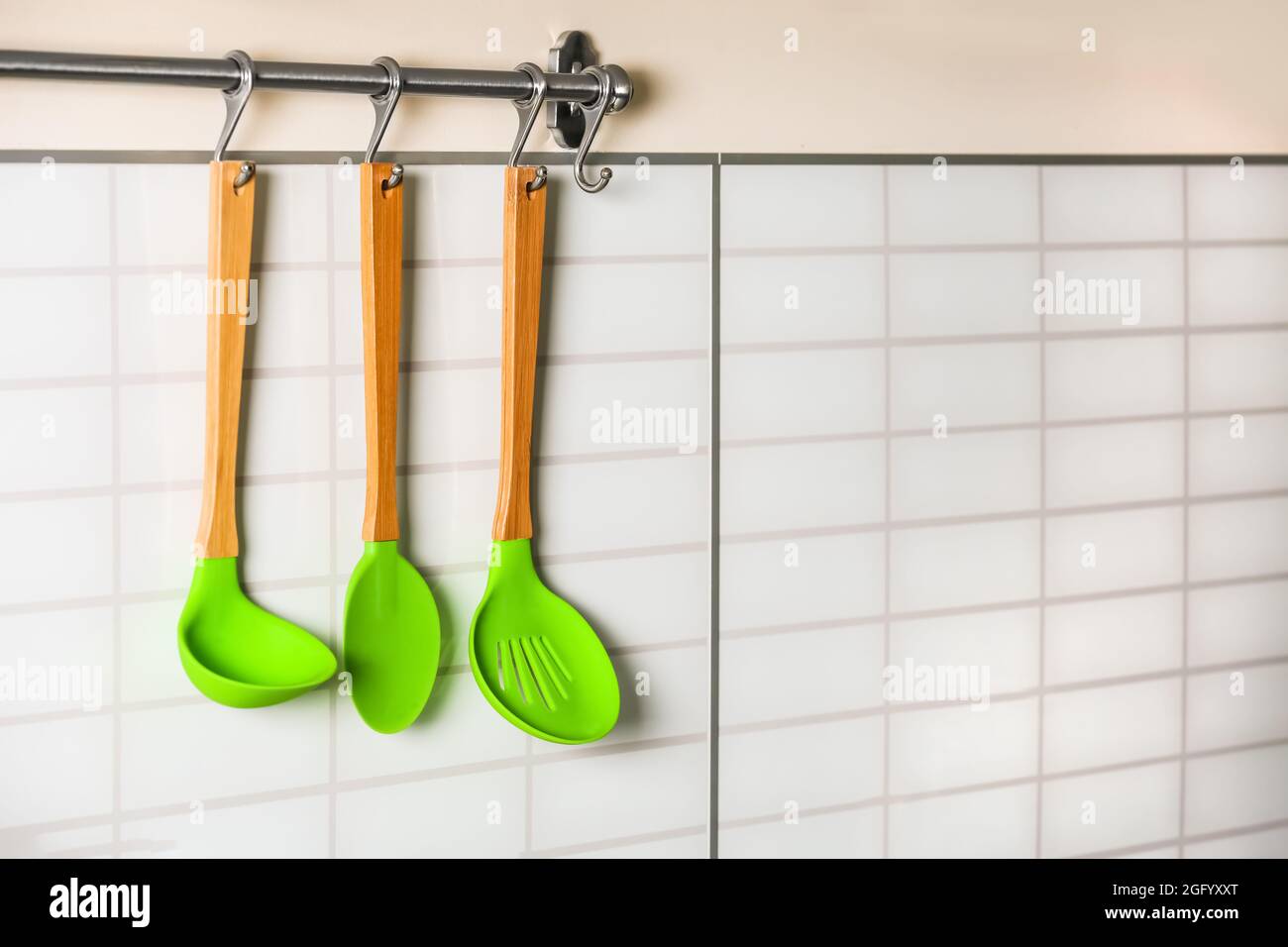 Set of wooden kitchen utensils hanging on wall Stock Photo - Alamy