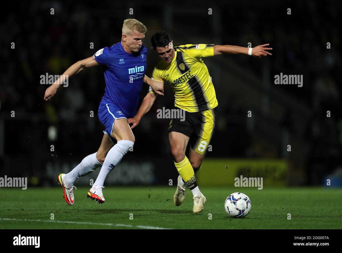 Burton Albion's Joe Powell (right) and Cheltenham Town's Lewis Freestone battle for the ball during the Sky Bet League One match at the Pirelli Stadium, Burton upon Trent. Picture date: Friday August 27, 2021. Stock Photo