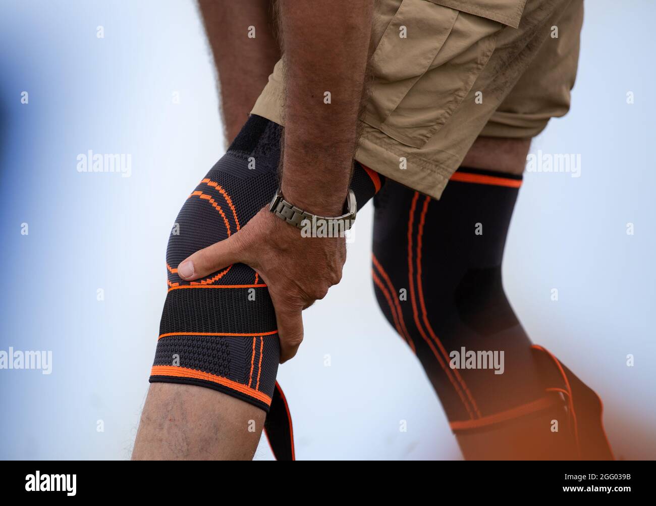 Hiker putting knee brace on. Injured leg and safety concept in