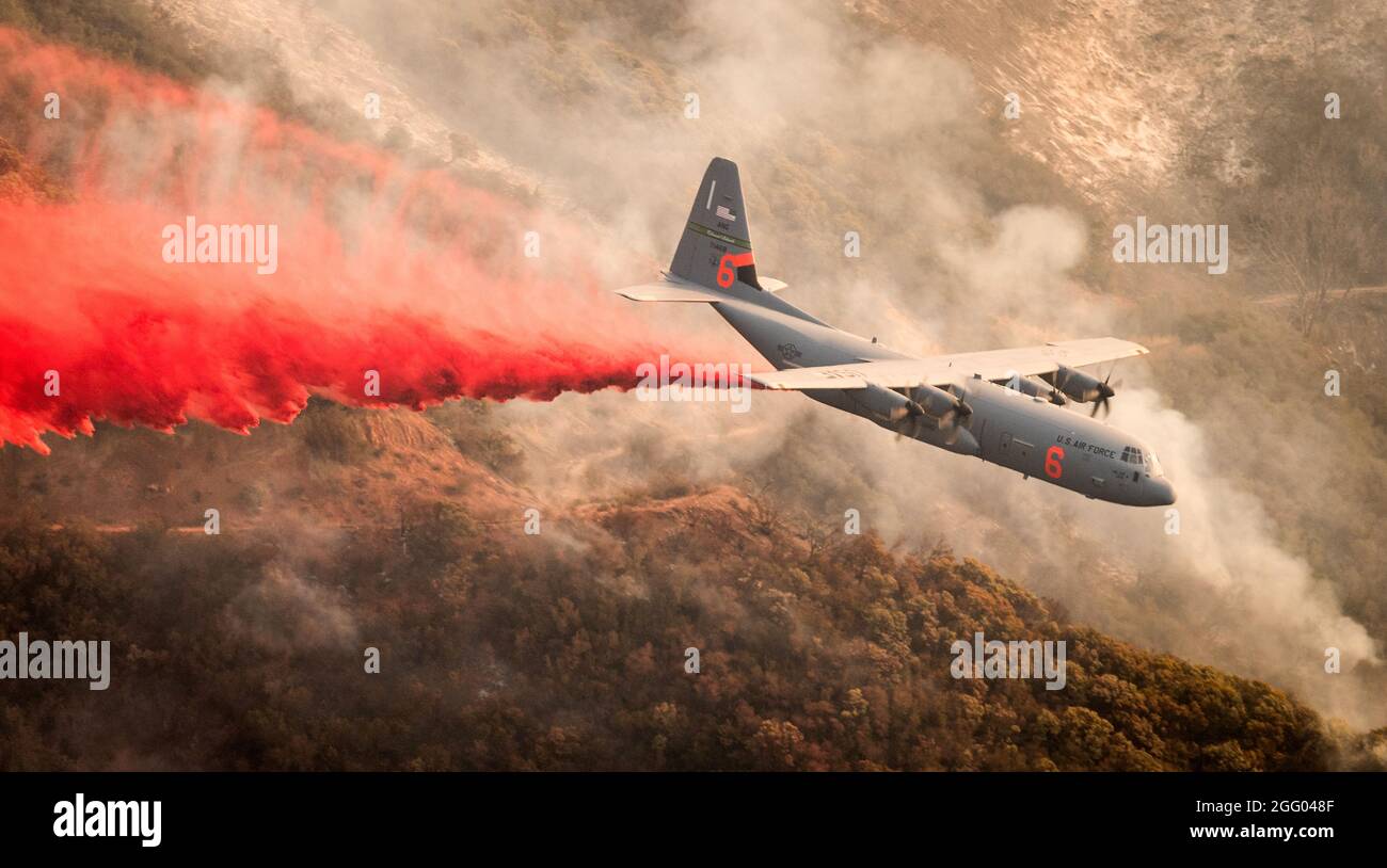 A C-130J Hercules assigned to the 146th Airlift Wing based at Channel Islands Air National Guard Base in Port Hueneme, Calif., which is carrying the Modular Airborne FireFighting System, drops fire retardant chemicals onto a ridge line above Santa Barbara, Calif., on Dec. 13, 2017, as part of the effort to contain the Thomas wildfire. (U.S. Air Force photo by J.M. Eddins Jr.) Stock Photo