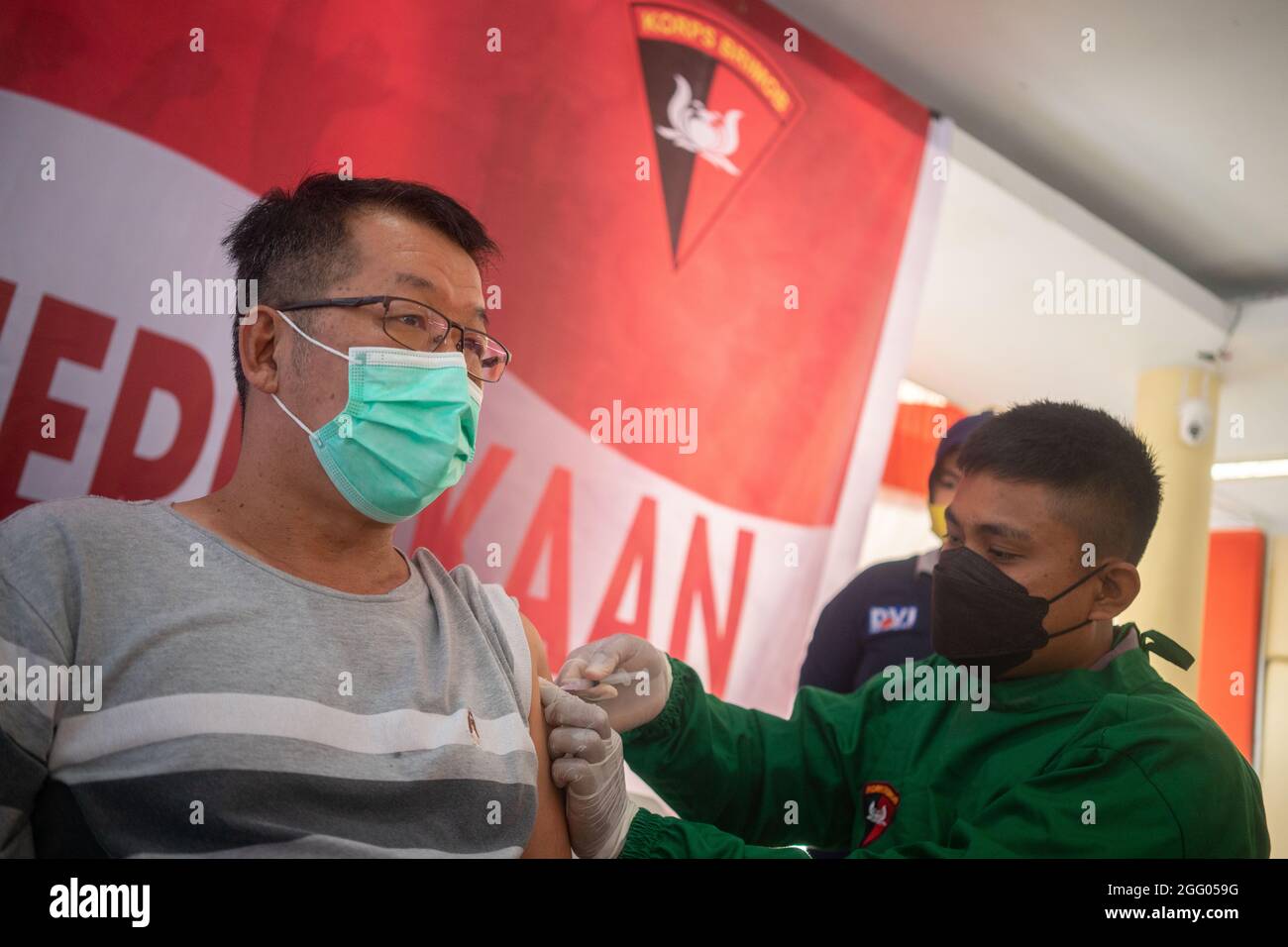 A health worker administers a dose of Sinovac COVID-19 vaccine to a foreign worker in Kendari. (Photo by Andry Denisah / SOPA Images/Sipa USA) Stock Photo