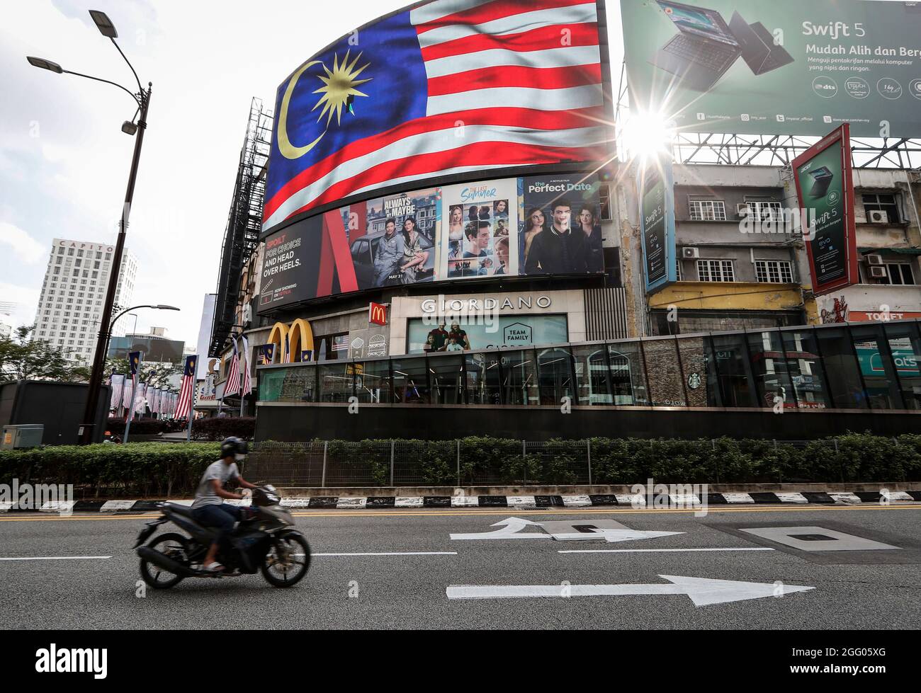 Kuala Lumpur, Malaysia. 27th Aug, 2021. A motorist rides past a digital