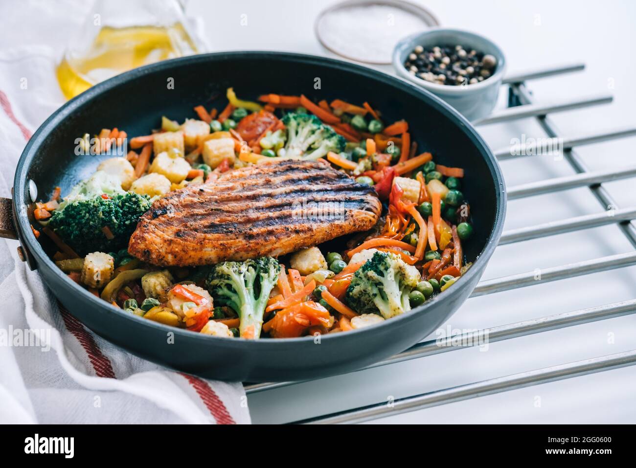 Grilled turkey steak fillet and fried vegetables mix in a black pan on the white table Stock Photo Alamy