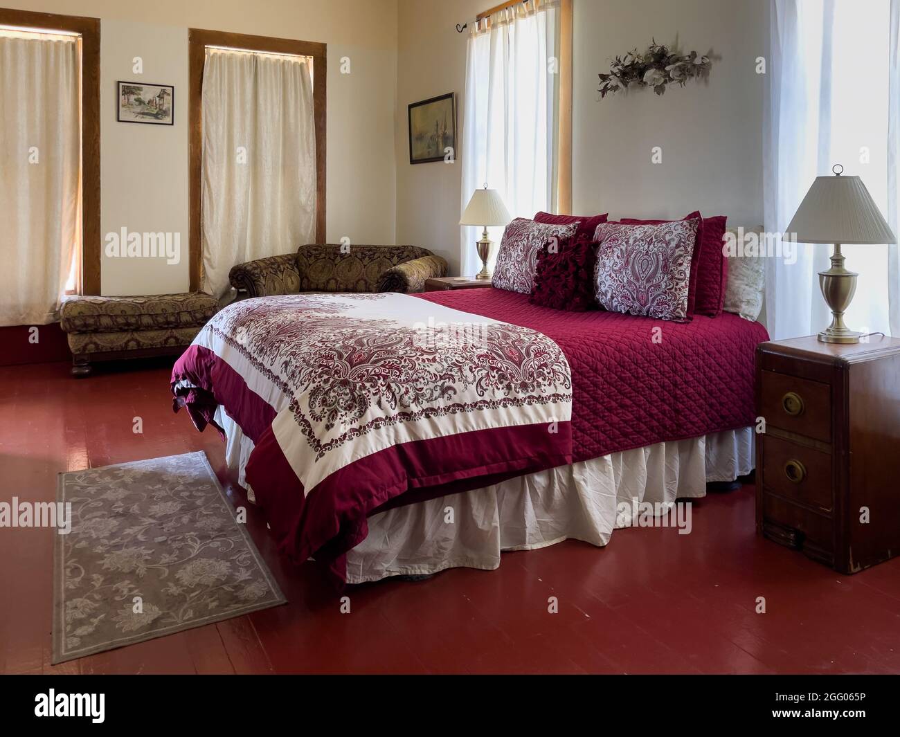Collier Hotel downstairs queen bedroom with decorative pillows in red and white Stock Photo