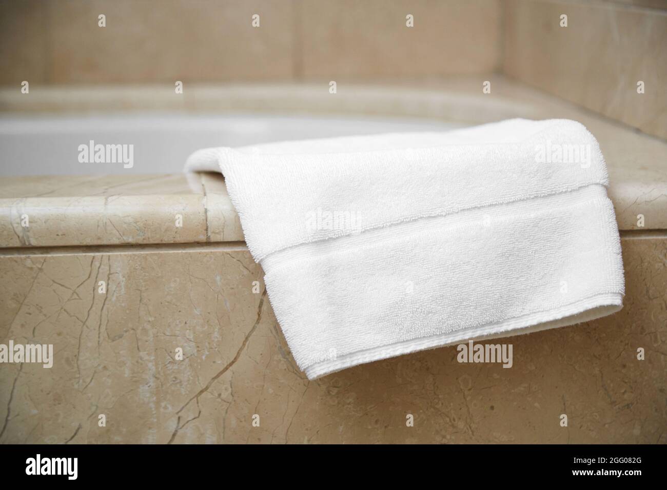 white clean foot towel on the edge of the bathroom. Stock Photo