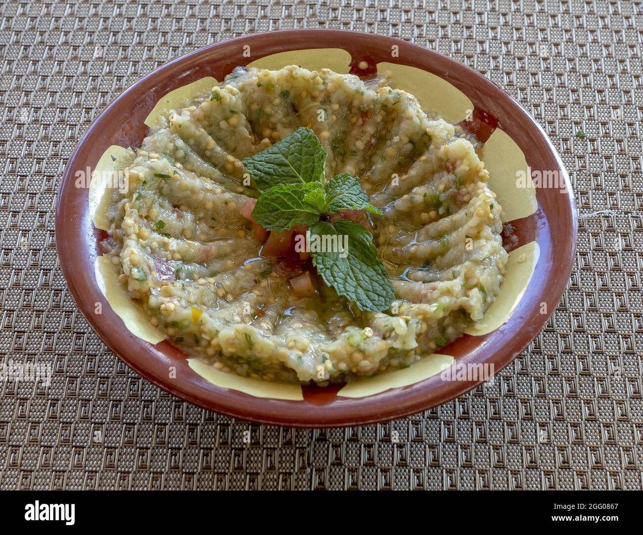 Closeup of a bowl of mutabal with mint leaves Stock Photo