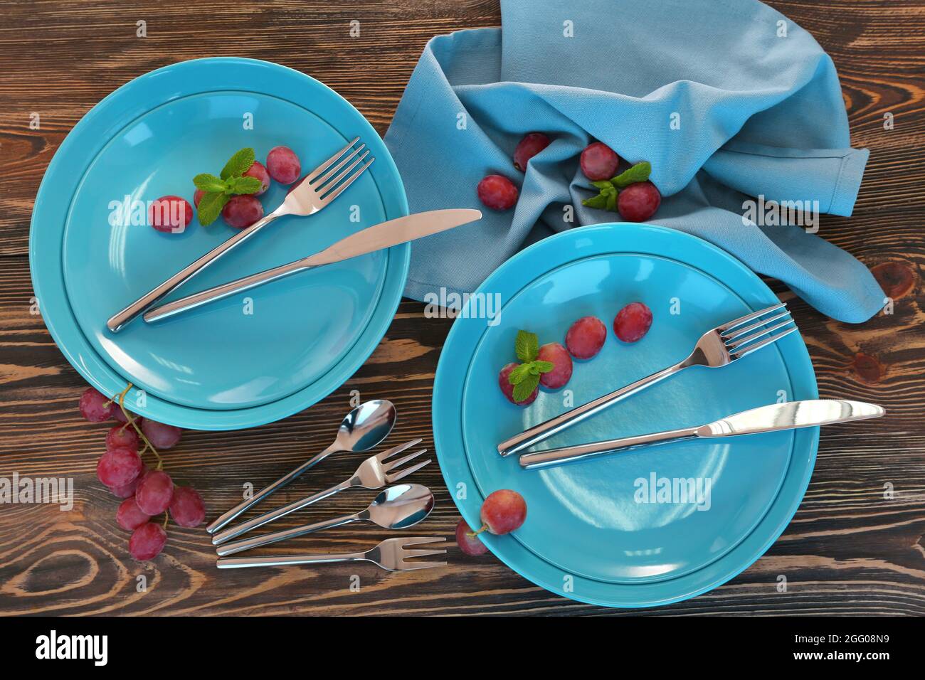 Blue plates and cutlery on wooden background Stock Photo Alamy