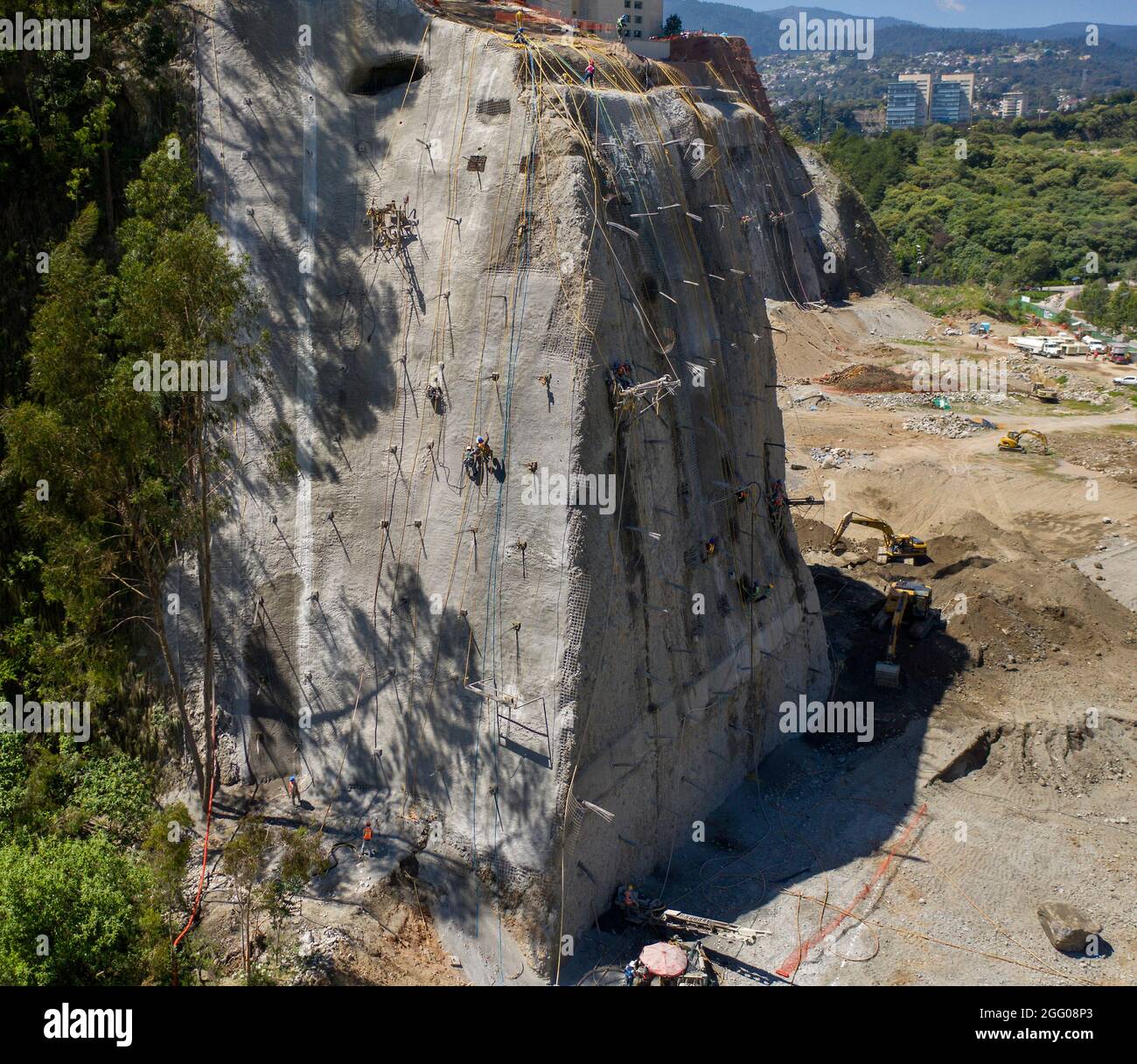 Workers reinforce a cliff face in the Santa Fe area of Mexico City, Mexico Stock Photo