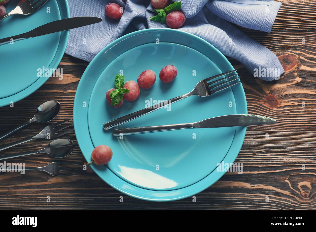 Blue plates and cutlery on wooden background Stock Photo Alamy