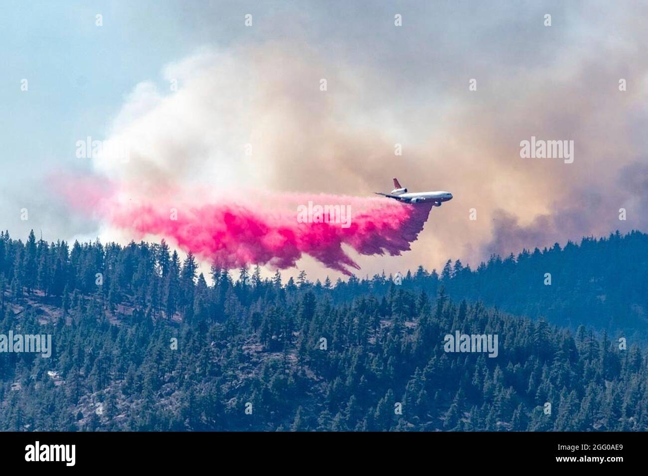 A civilian DC-10 jet air tanker drops fire retardant on the Beckwourth Complex Fire July 9, 2021 near Frenchman Lake, California. Stock Photo