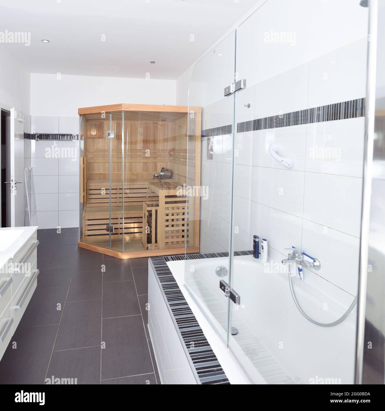 bathroom at home with homemade sauna bath tub grey and white tiles Stock Photo