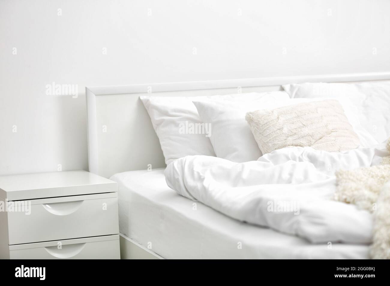 White interior of modern bedroom with cozy double bed Stock Photo - Alamy