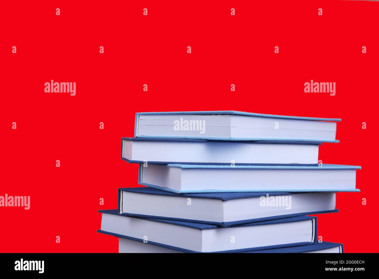Pile of books on red background Stock Photo - Alamy