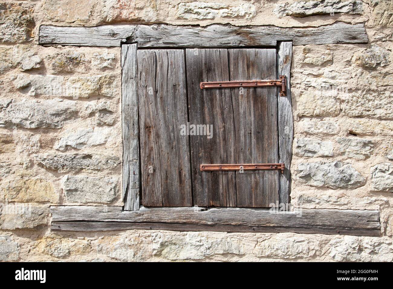Closed old weathered shutter in a stone wall Stock Photo - Alamy