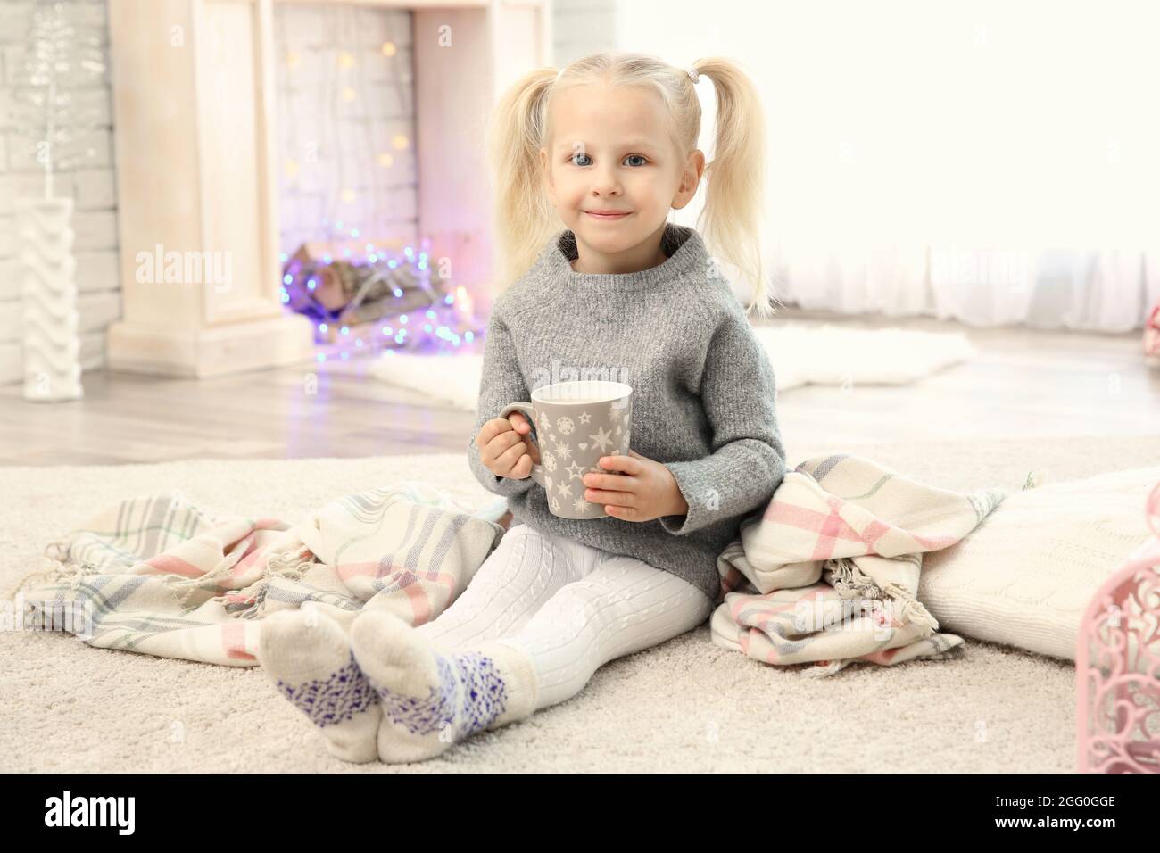 Cute little girl sitting on floor with cup of coffee Stock Photo - Alamy