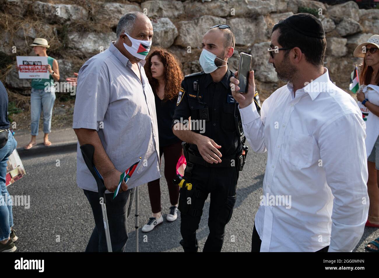 Jewish and Palestinian protestors in Sheikh Jarach during the weekly protest in front of the Israeli Police checkpoint at the entrance to the neigberhood - which is monitoring entrance of non-residents since last April. Sheikh Jarach. Jerusalem, Israel. 28th Aug 2021. (Photo by Matan Golan/Alamy Live News) Stock Photo