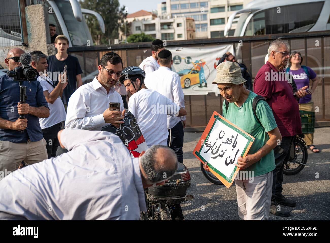 Jewish and Palestinian protestors in Sheikh Jarach during the weekly protest in front of the Israeli Police checkpoint at the entrance to the neigberhood - which is monitoring entrance of non-residents since last April. Sheikh Jarach. Jerusalem, Israel. 28th Aug 2021. (Photo by Matan Golan/Alamy Live News) Stock Photo