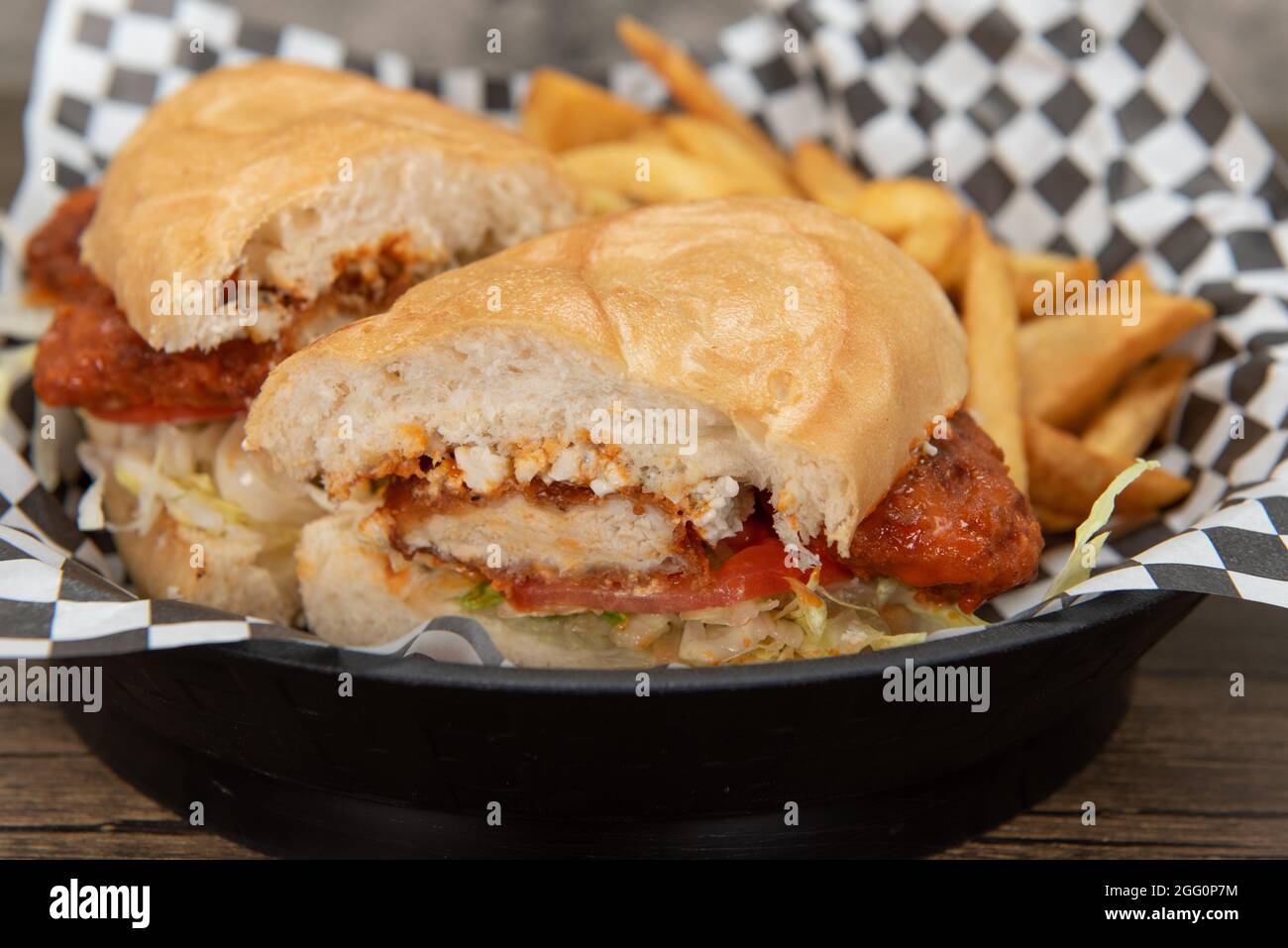Spicy chicken strips on a sandwich  with melted cheese served with steak french fries for an appetizing meal. Stock Photo