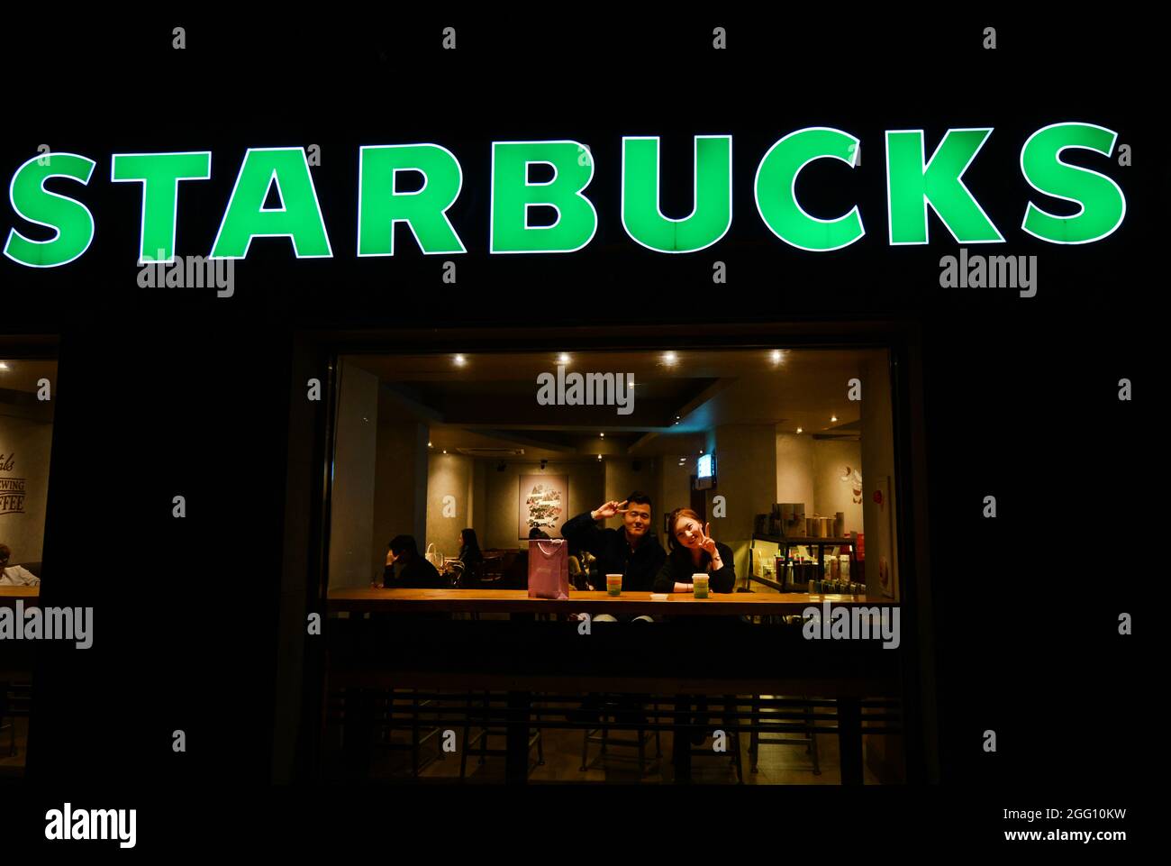 A Korean couple sitting in a Starbucks coffee house in Seoul, South Korea. Stock Photo