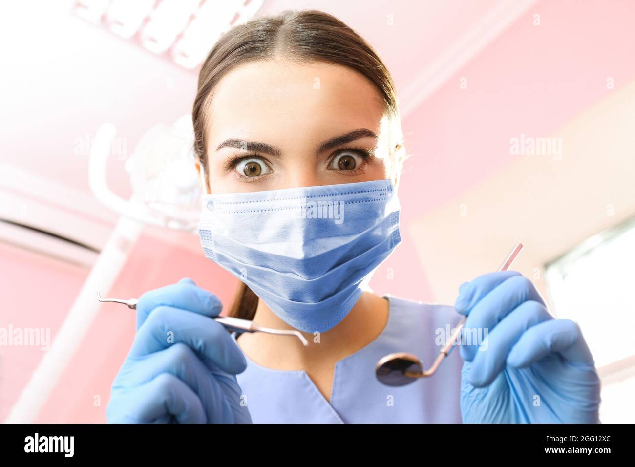 Dentist with mirror and periodontal explorer in clinic Stock Photo - Alamy