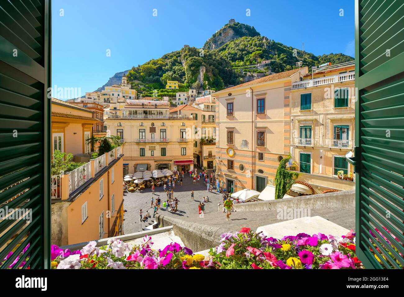 View from an open window with shutters over the steps, Piazza Duomo, and colorful old town of Amalfi, Italy, on the Amalfi Coast. Stock Photo