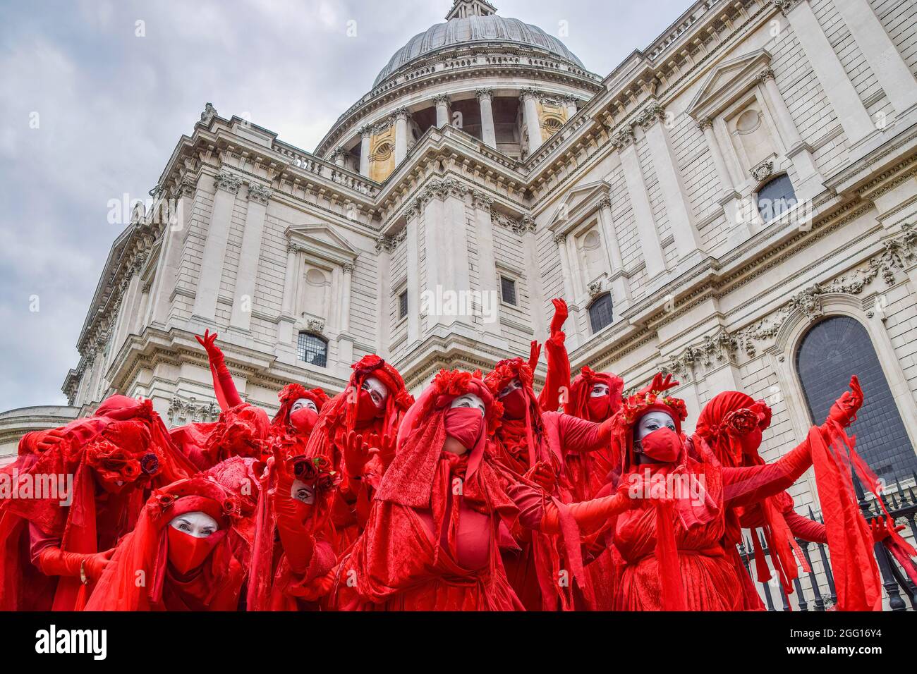 London, UK. 27th Aug, 2021. Extinction Rebellion's Red Rebel Brigade perform outside St Paul's Cathedral during the demonstration. Extinction Rebellion protesters staged the Blood Money March, part of their two-week Impossible Rebellion campaign, targeting the City of London, the capital's financial hub. (Photo by Vuk Valcic/SOPA Images/Sipa USA) Credit: Sipa USA/Alamy Live News Stock Photo