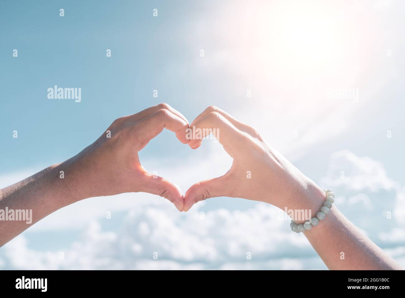 Woman hand do heart shape on blue sky and beach background Stock Photo ...