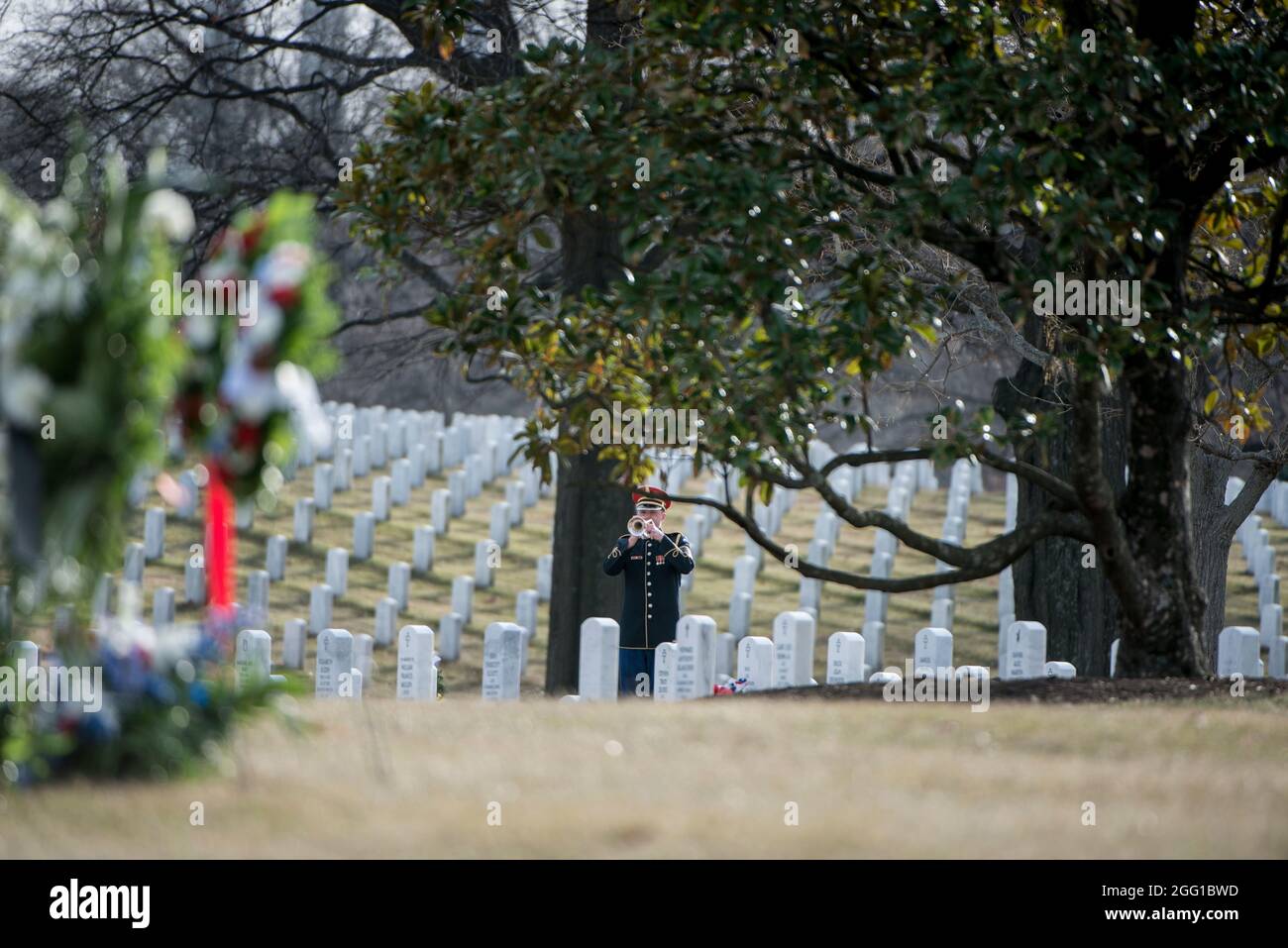 A bugler from The U.S. Army Band, “Pershing’s Own”, plays taps during the funeral of U.S. Army Sgt. 1st Class Mihail Golin in Section 60 of Arlington National Cemetery, Arlington, Virginia, Jan. 22, 2018. Golin, an 18B Special Forces Weapons Sergeant assigned to 10th Special Forces Group (Airborne) died Jan. 1, 2018, as a result of wounds sustained while engaged in combat operations in Nangarhar Province, Afghanistan.  Golin deployed to Afghanistan in September 2017 with the 2nd Battalion, 10th Special Forces Group, in support of Operation Freedom’s Sentinel.  Golin enlisted Jan. 5, 2005 and t Stock Photo