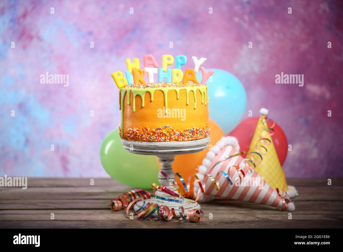 Tasty birthday cake with party hats on colorful background Stock Photo -  Alamy