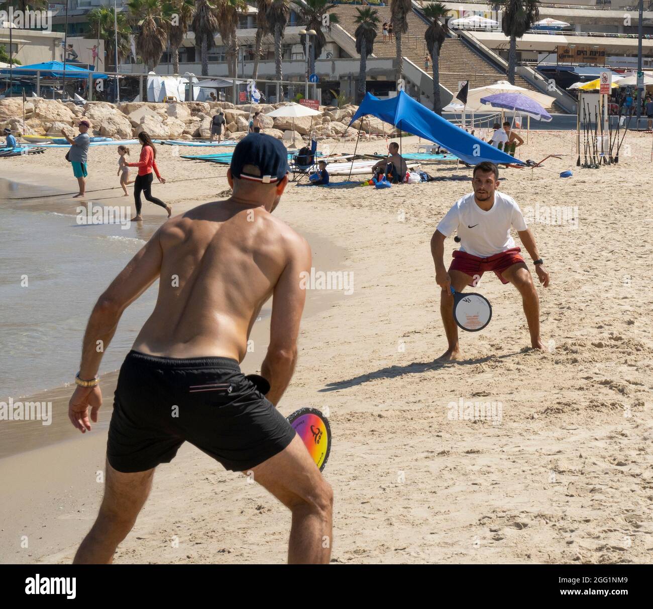 Tel Aviv, Israel - August 15th, 2021: Two young men playing matkot on ...