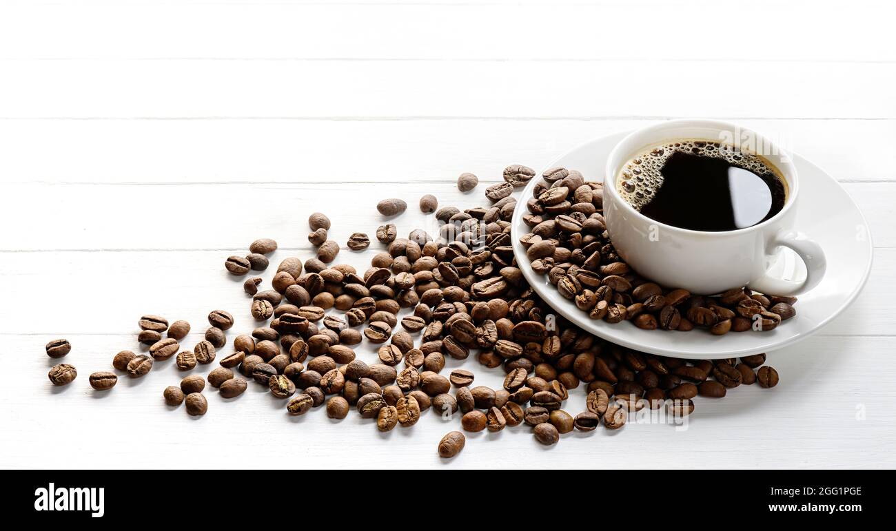 https://c8.alamy.com/comp/2GG1PGE/black-coffee-in-white-ceramic-cup-with-coffee-beans-on-a-white-table-2GG1PGE.jpg