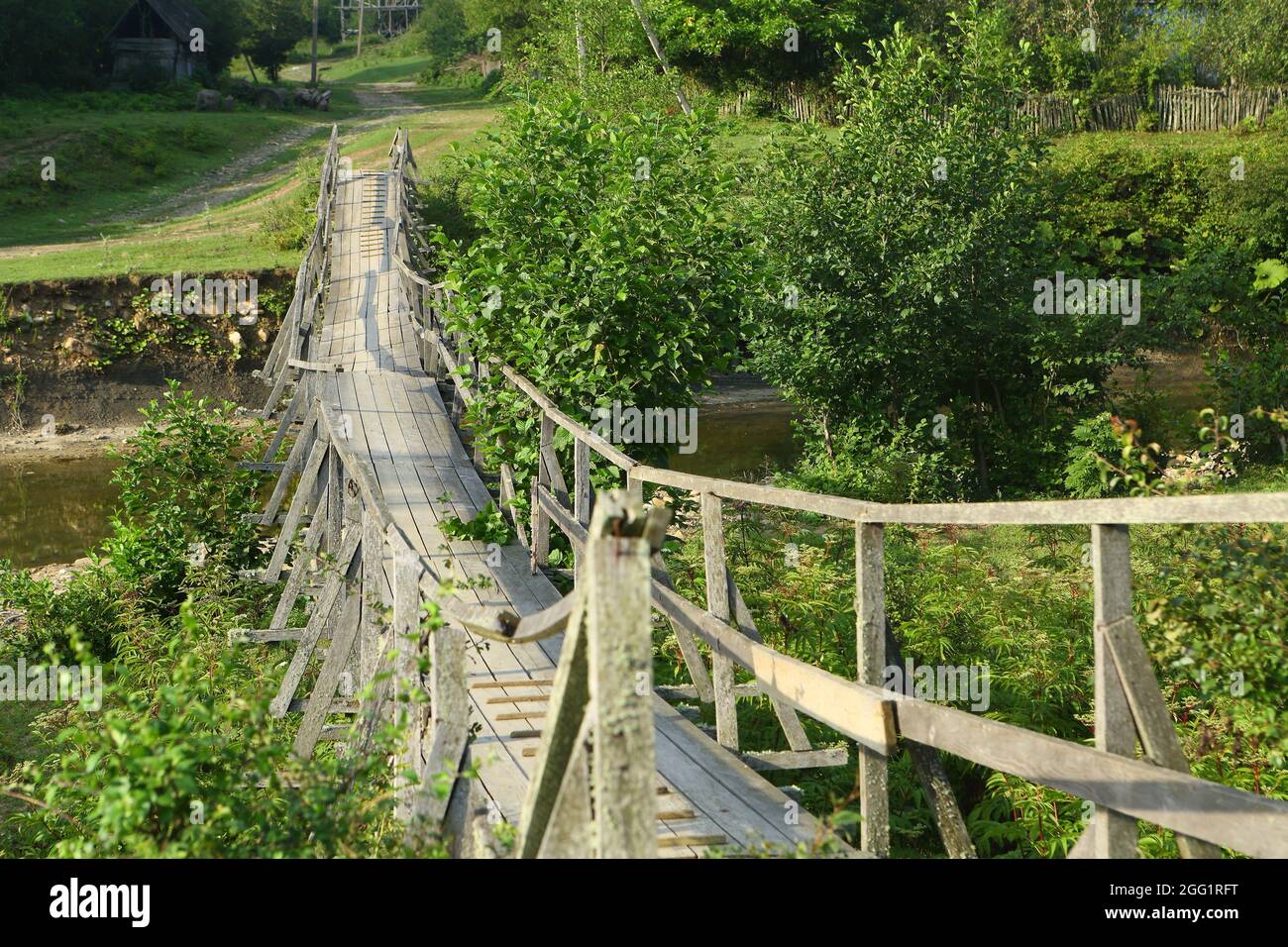 Old wooden suspension bridge over the river Stock Photo - Alamy