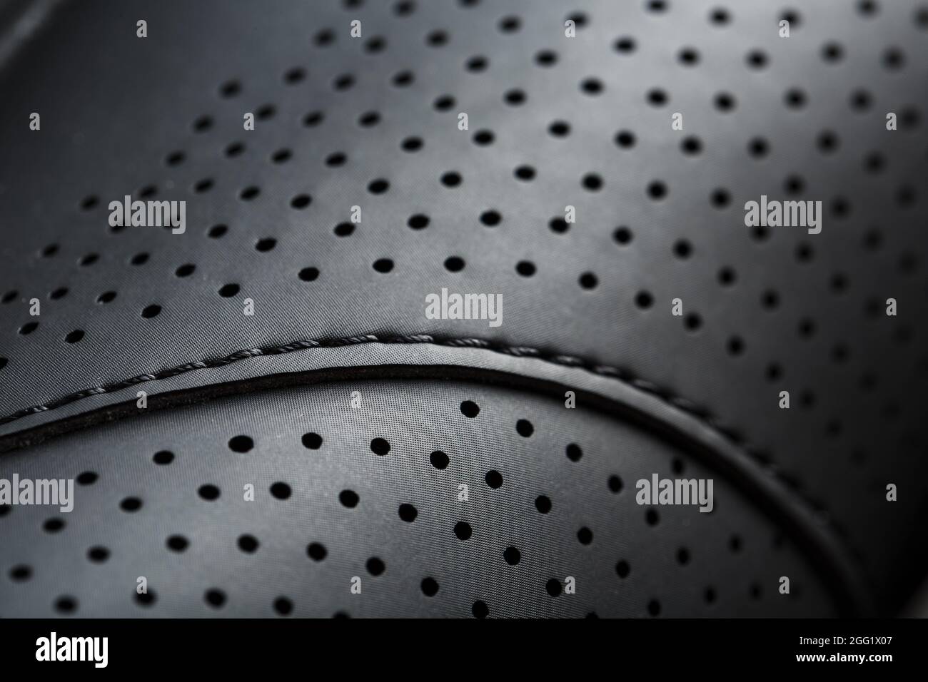 Perforated material made of black imitation leather in full screen. Close-up Stock Photo