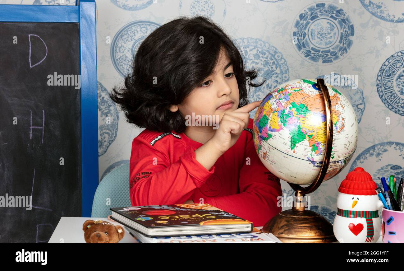 Boy studying with Glob - QATAR Stock Photo