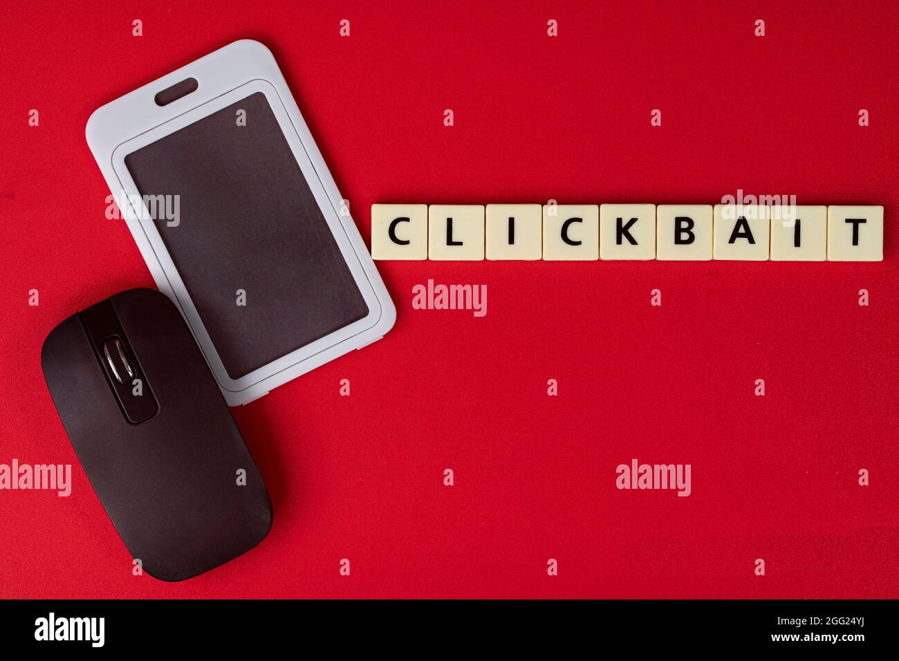 Mobile phone replica, mouse with text Clickbait Marketing. Clickbait is a method to entice user to click a post in the internet Stock Photo