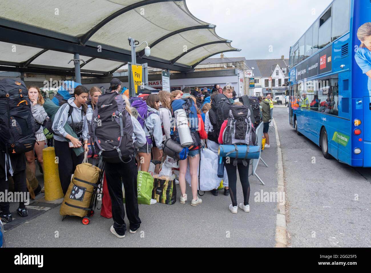 Young Festivalgoers queueing outside Newquay Train Station waiting for buses to transport them to the Boardmasters Festival in Newquay in Cornwall. Stock Photo