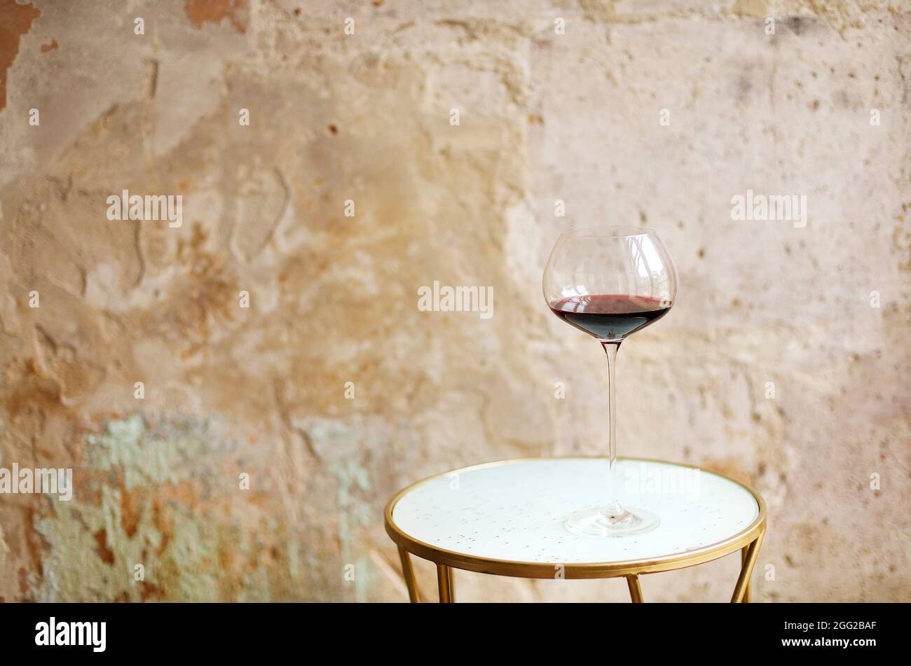 One wineglasse with red wine during party with copy space. Celebration and holiday concept Stock Photo