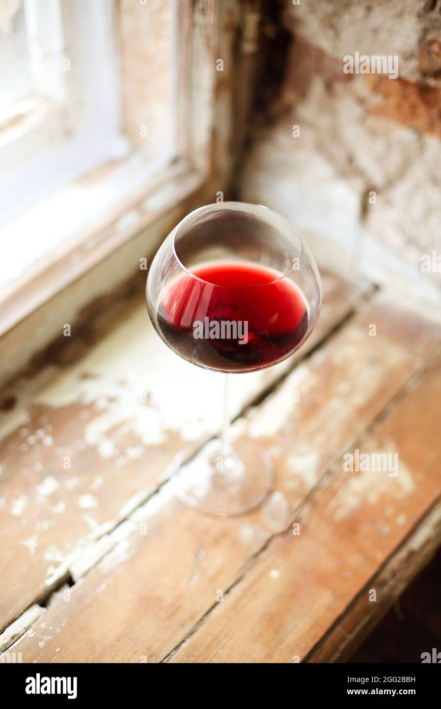 One wineglasse with red wine during party with copy space. Celebration and holiday concept Stock Photo