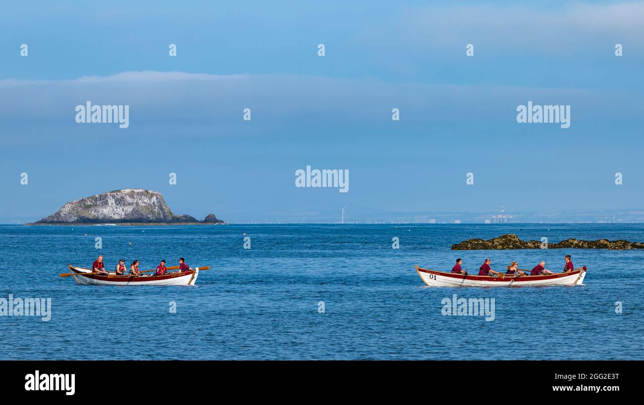 North Berwick, East Lothian, Scotland, UK  28th August 2021. Coastal Rowing Regatta: The annual event, cancelled last year, takes place this year in a reduced form with only seven clubs from the South part of the Firth of Forth  participating. Pictured: skiffs in West Bay Stock Photo